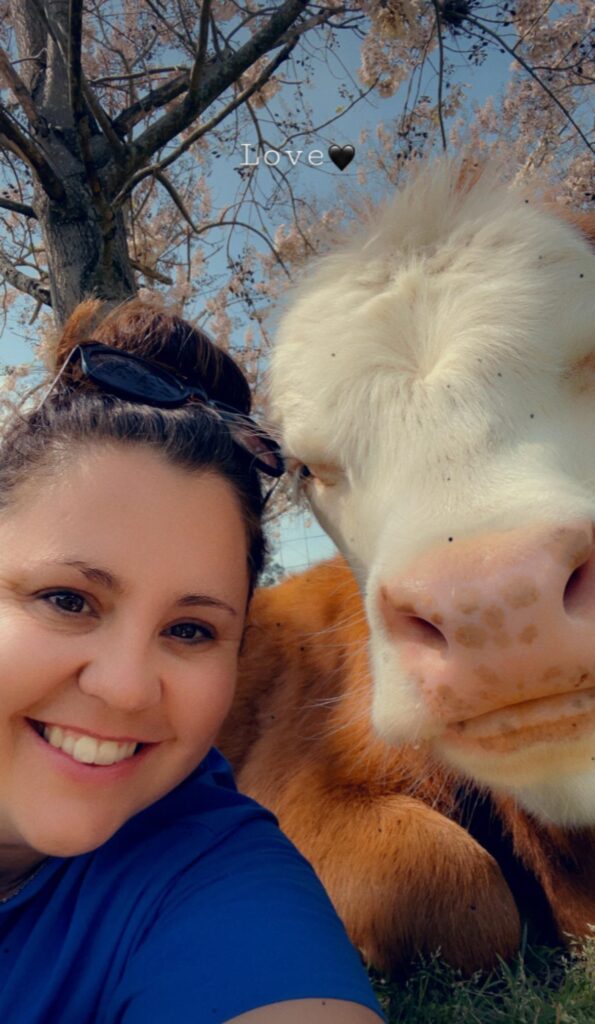a woman taking a selfie with her cow