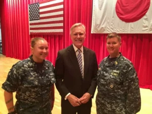 Two Sailors pose for a photo with Secretary of the Navy Ray Mabus.