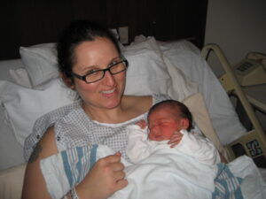 A woman in a hospital bed holding her newborn son.