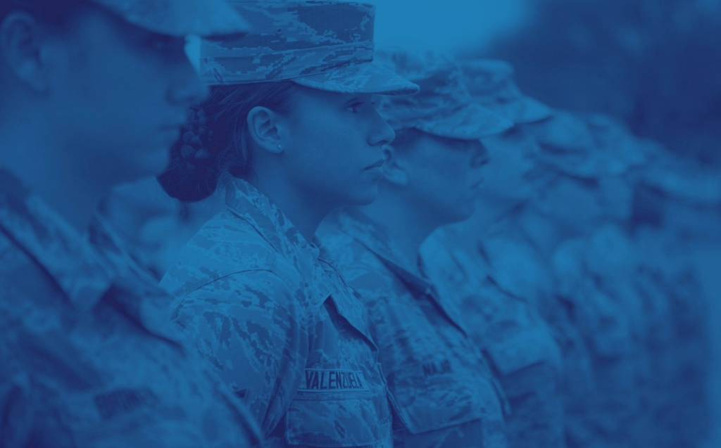A blue-tinted photo of military women in uniform standing in formation